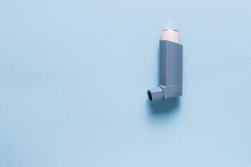 Asthma inhaler on the blue background - obrazy, fototapety, plakaty