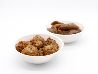 Group photograph of indian pickles or achar like amla pickle and lemon pickle, sarved in white ceramic bowl, selective focus