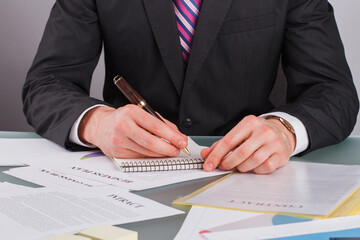 Businessman hands working with documents close up. Business man hand making a note in paper notepad. New business project.