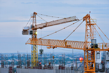 Fototapeta na wymiar Construction of High rise buildings with Tower cranes is the key to transporting materials to the top of the building.
