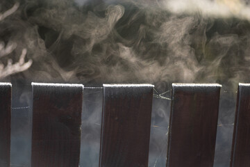 Sublimation process on cold autumn morning - frost from the fence heated up by sun turns into steam