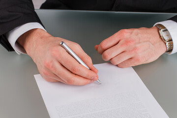 Business investor signing a contract close up. Businessman hands puts a signature on business document. Financial deal concept.