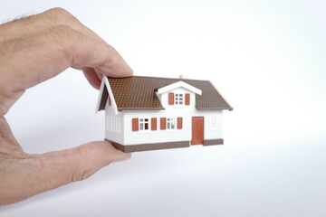 maison entre deux doigts fond blanc