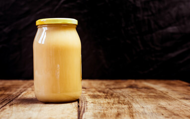 Homemade jar of fresh natural honey isolated on vintage wooden board