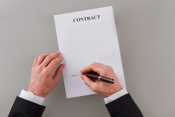 Close up businessman signing business papers. Hands of entrepreneur signing a business contract.