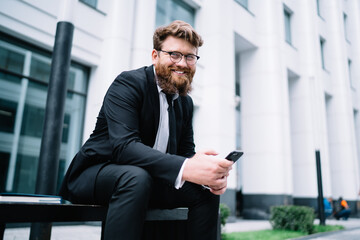 Fototapeta premium Serious businessman smiling and looking at camera