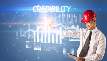Handsome businessman with helmet drawing CREDIBILITY inscription, architecture business plan concept