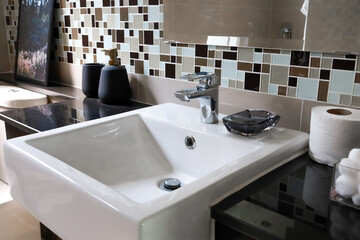 Stainless steel faucets attached to bathroom sinks The unclear part is to make the subject stand...