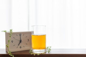 朝目覚まし時計を見て一杯のお茶を飲むモーニングルーティーン