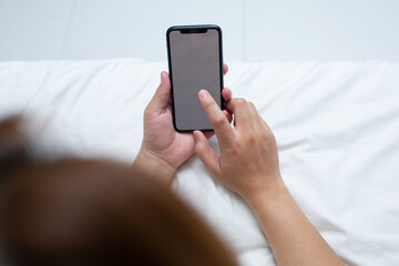 Woman use of mobile phone on bed