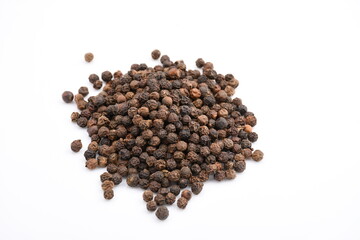 A molehill of a handful of black pepper scattered on a plain while background.