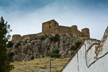 Fototapeta na wymiar Castillo fortaleza en colina de roca gris visto desde su base