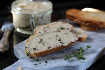Anchovy butter spread on toast, with anchovy butter jar in the background.