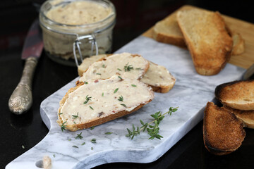 Anchovy butter spread on toast, with anchovy butter jar in the background.