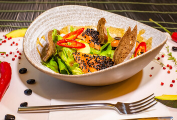 Salmon fillet salad with fried spinach, black sesame seeds and black bread. Selective focus. Super short focus