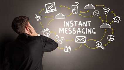 businessman drawing social media icons with INSTANT MESSAGING inscription, new media concept