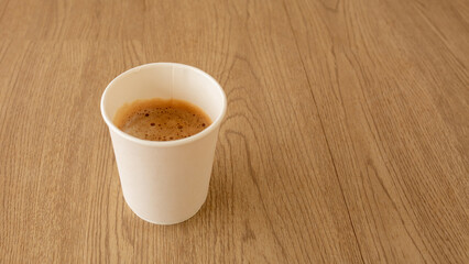 Coffee in paper cup on wood table