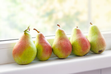 Pears on the windowsill. Juicy pears are stacked in a row. Fruit harvest. Selective soft focus. Healthy organic food.
