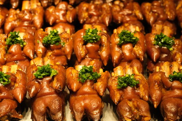 rows of braised trotters (pig's feet) with shallots. Traditional Chinese snack