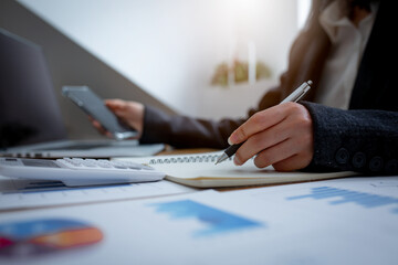 Financial Businesswomen analyze the graph of the company's performance to create profits and...