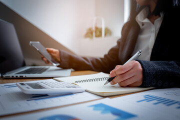 Financial Businesswomen analyze the graph of the company's performance to create profits and...