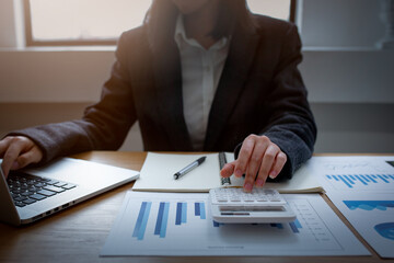Financial Businesswomen analyze the graph of the company's performance to create profits and...
