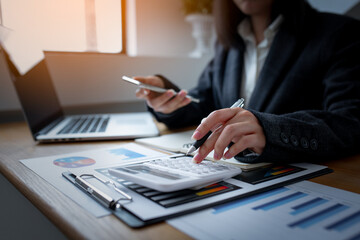 Fototapeta premium laptop calculator pen business document concept, Asian Business fmale working in his laptop in a modern office.