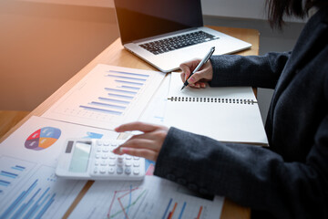 Financial Businesswomen analyze the graph of the company's performance to create profits and growth, Market research reports and income statistics, Financial and Accounting concept.