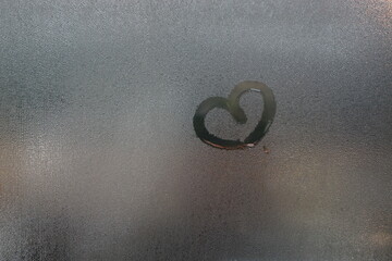 condensation water droplets in mirror for background.Hand Drawn heart on the window.
