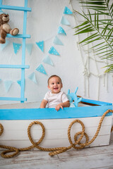portrait of a happy kid boy sitting in a wooden boat