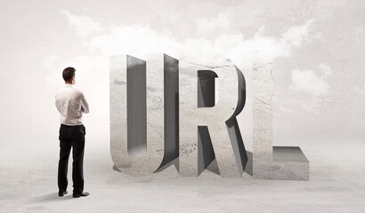 Rear view of a businessman standing in front of URL abbreviation, attention making concept