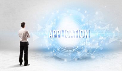 Rear view of a businessman standing in front of APPLICATION inscription, modern technology concept