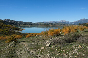 Blue lake landscape near malaga in spain with a lof of rocks and plants
