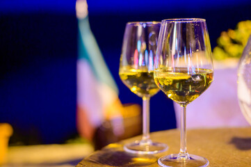 Two glasses of cold dry white wine served outdoor in cafe at night in Italy