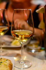 Glass of cold dry white wine served outdoor in cafe at night in Italy