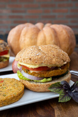 Making fresh and healthy vegetarian hamburgers with grilled pumpkin burgers, organic buns and vegetables