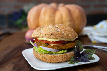 Making fresh and healthy vegetarian hamburgers with grilled pumpkin burgers, organic buns and vegetables