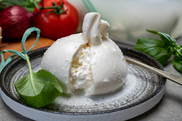 Eating of fresh handmade soft Italian cheese from Puglia, white balls of burrata or burratina...
