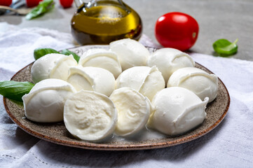 Tasty italian food, fresh white buffalo mozzarella soft cheese balls from Campania, tomatoes, fresh basil and olive oil