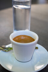 Drinking of strong black espresso coffee on outdoor terrace in cafe