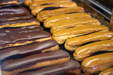 Assortment of french fresh baked eclair sweet pastry  in confectionery shop