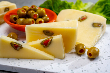 Cheese collection, fresh Italian pecorino cheese made from sheep milk filled with green olives stuffed with red paprika