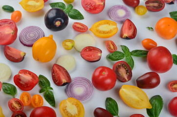 lots of tomatoes, onion slices and basil leaves isolated on a white background
