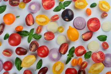 lots of tomatoes, onion slices and basil leaves isolated on a white background