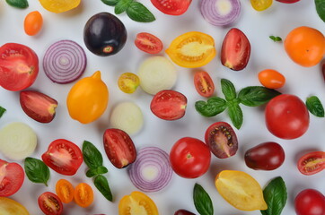 lots of tomatoes, onion slices and basil leaves isolated on a white background