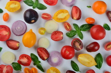 lots of tomatoes, onion slices and basil leaves isolated on a white background