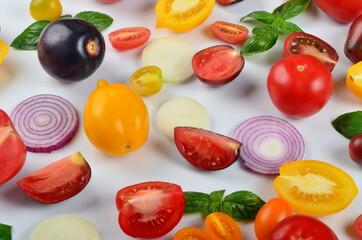 lots of tomatoes, onion slices and basil leaves isolated on a white background