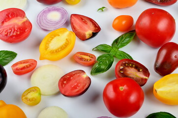 lots of tomatoes, onion slices and basil leaves isolated on a white background