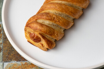 single sausage roll on white plate 