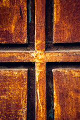 Cross plus sign on rusted metal gate